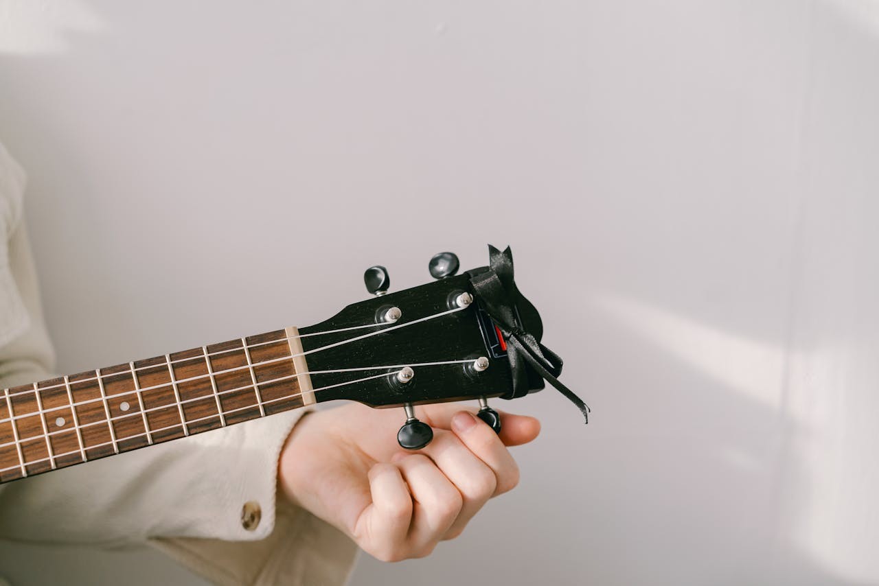 A hand tuning a stringed instrument